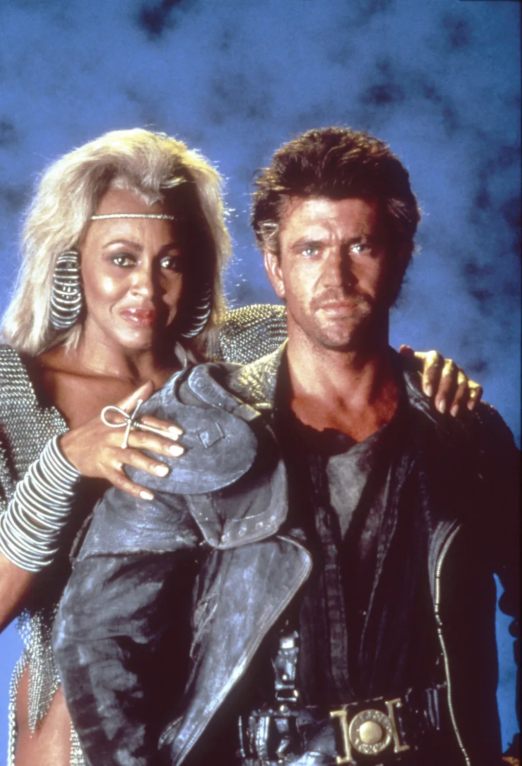 Tina Turner meghalt,  Mad Max Beyond Thunderdome Cinema movie film still movie still publicity still production still australian 1980s eighties adventure pose leather jacket buckle chainmail dress Vertical FILM MAN WOMAN BELT 