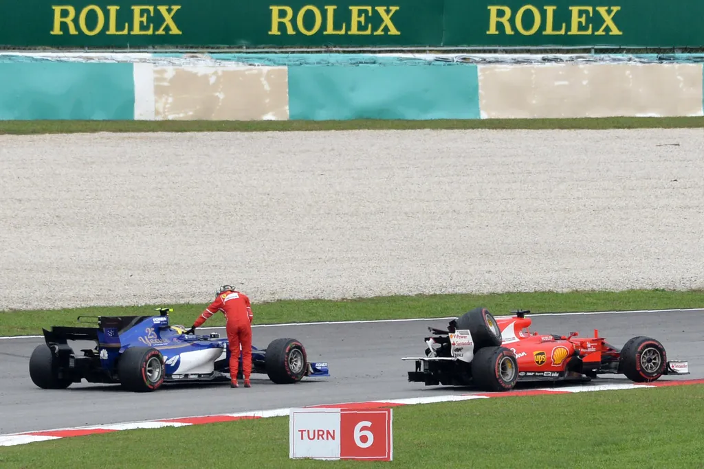 auto-prix Horizontal Ferrari's German driver Sebastian Vettel is given a ride by Sauber's German driver Pascal Wehrlein after he crashed past the chequered flag during the Formula One Malaysia Grand Prix in Sepang on October 1, 2017.   / AFP PHOTO / ROSLA