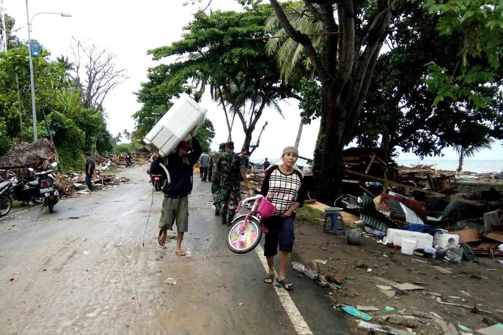 Horizontal Residents evacuate from damaged homes on Carita beach on December 23, 2018, after the area was hit by a tsunami on December 22 that may have been caused by the Anak Krakatoa volcano. - At least 43 people have been killed and nearly 600 injured 