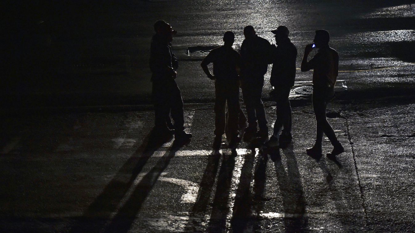 Horizontal POLITICAL CRISIS POWER CUT SILHOUETTE Security guards stand outside a closed shopping mall during a power outage in Caracas, on March 29, 2019. - Caracas and other major Venezuelan cities were hit by a new electricity blackout on Friday, as the