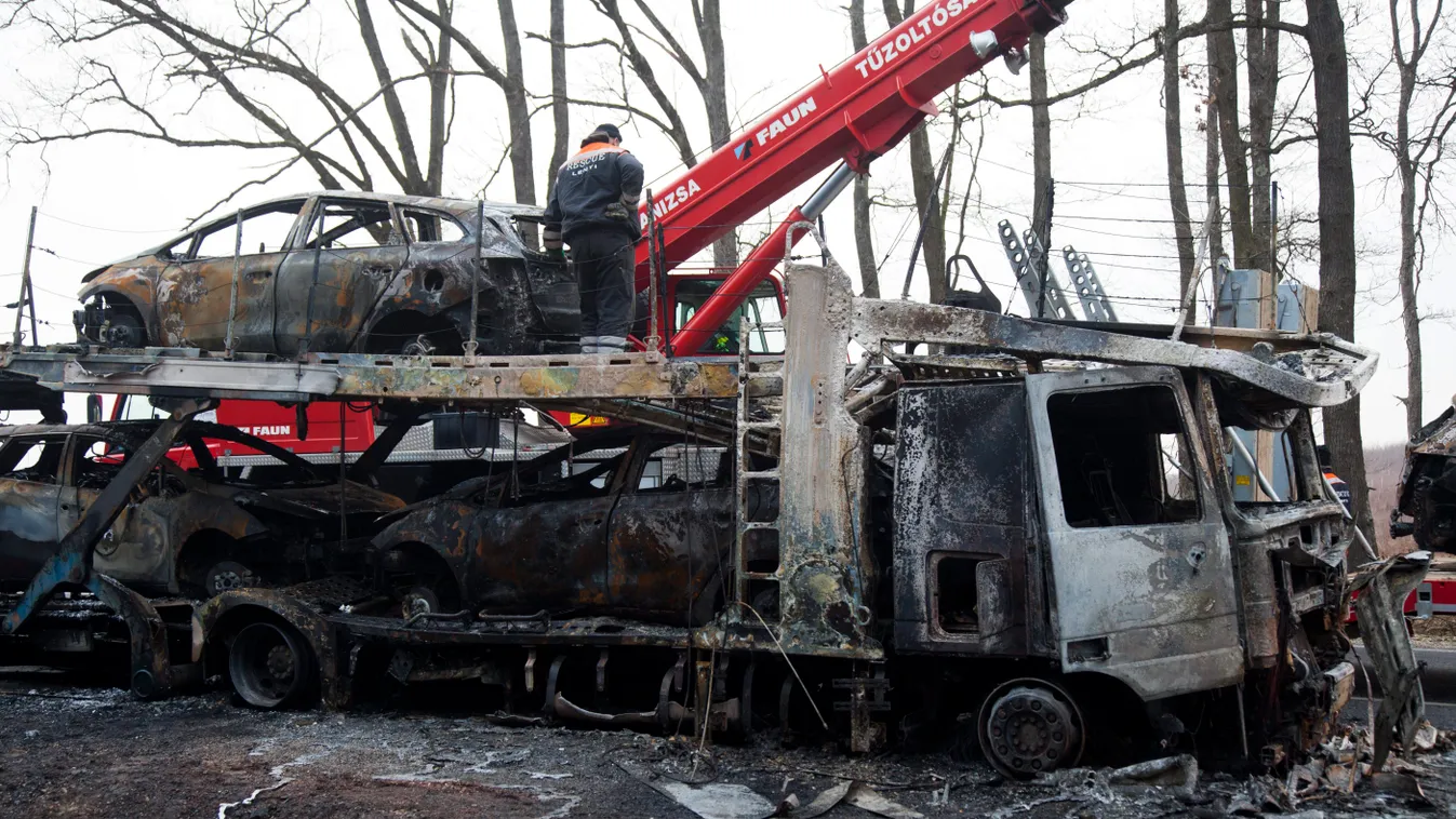 Kozmadombja, 2015. március 14.
Kiégett autókat pakolnak a tűzoltók és a különleges műszaki mentők egy gépkocsikat szállító kamionról a 86-os számú főúton, Kozmadombja külterületén 2015. március 14-én. A tűz egy lengyel kamionon ütött ki, amely nyolc új sz