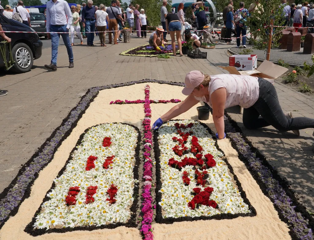 Corpus Christi vallásos körmenet alkalmából virágszőnyeget terítenek le Spycimierzben, Lengyelországban, vallás, kereszténység, felvonulás, virág, virágszirom, ünnep, ünneplés, vallási ünnep 