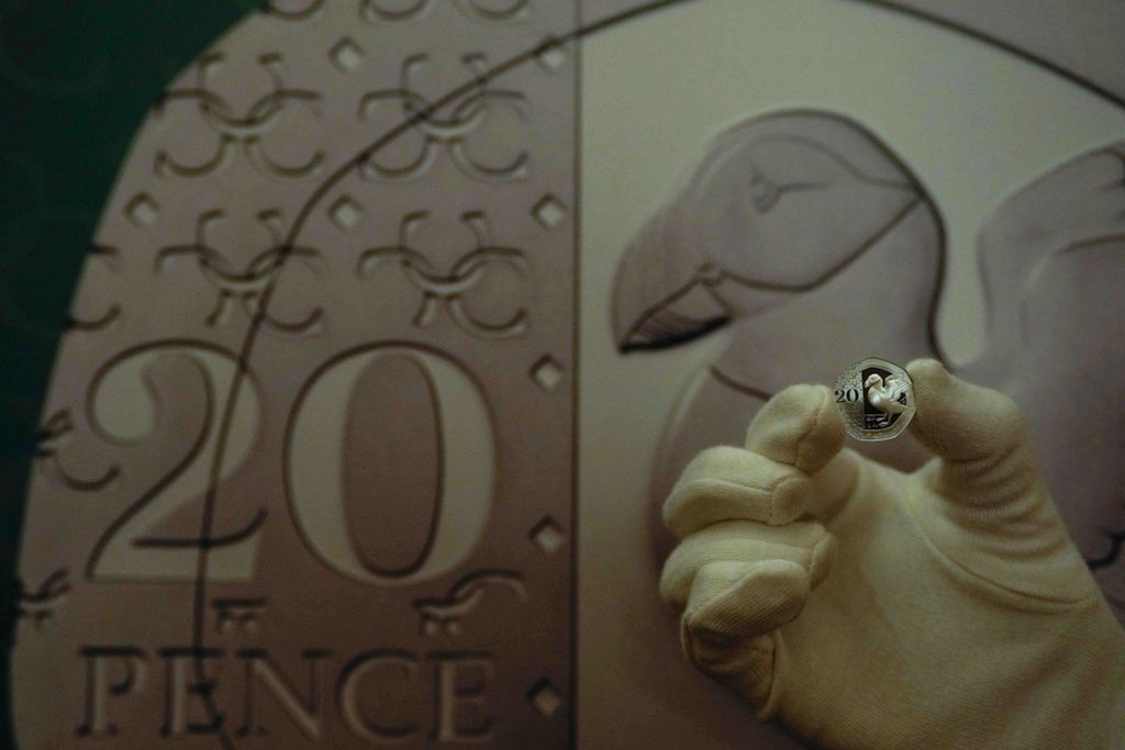 III. KÁROLY London, 2023. október 12.
A Brit Királyi Pénzverde egyik munkatársa mutatja az új 20 pennys érmét, amelyen a lunda motívuma látható a Londonban tartott sajtótájékoztatón 2023. október 12-én. A pénzverde tájékoztatása szerint ez év végén kezdik