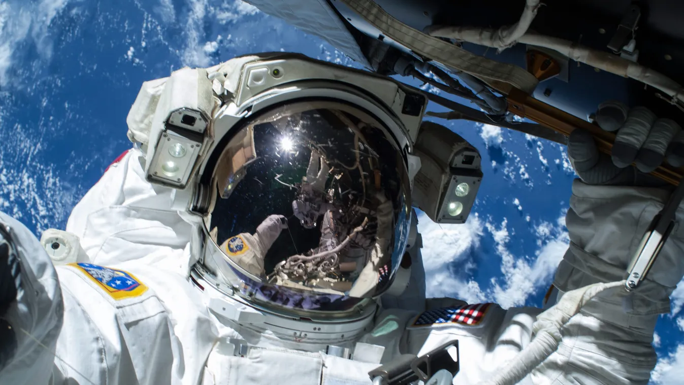 Barry Wilmore amerikai űrhajós kábelt fektet a Föld körül keringő Nemzetközi Űrállomás külsején a munkához szükséges három tervezett űrséta első alkalmával. A sisakrostélyán Terry Virts amerikai űrhajós képe tükröződik 