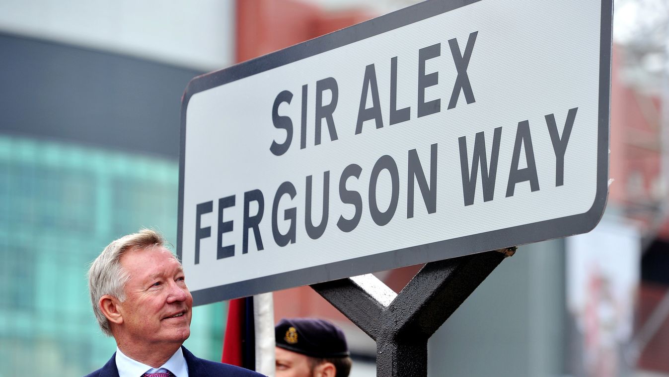(FILES) In this file picture taken on October 14, 2013 Former Manchester United manager Sir Alex Ferguson unveils a sign after a road near to Old Trafford Stadium was renamed in his honour in Manchester, north-west England.  Former United boss Alex Fergus