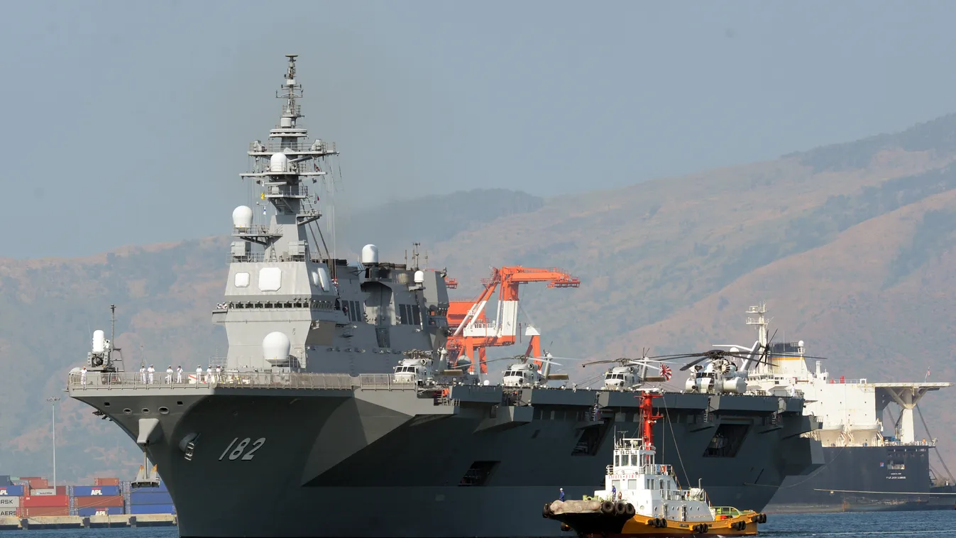 Horizontal Japanese helicopter carrier Ise is towed as it prepares to dock at the former US naval base, Subic port, north of Manila on April 26, 2016. 
Ise (DDH 182), which is in the Philippines for a four-day goodwill visit, marking a third time Japanese