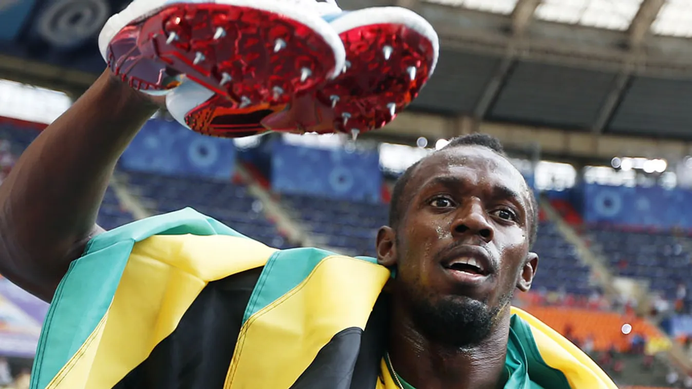 A jamaicai Usain Bolt edzőcipőivel, miután aranyérmet nyert a 4x100-as váltóban a moszkvai atlétikai világbajnokságon a Luzsnyiki Stadionban 2013. augusztus 18-án