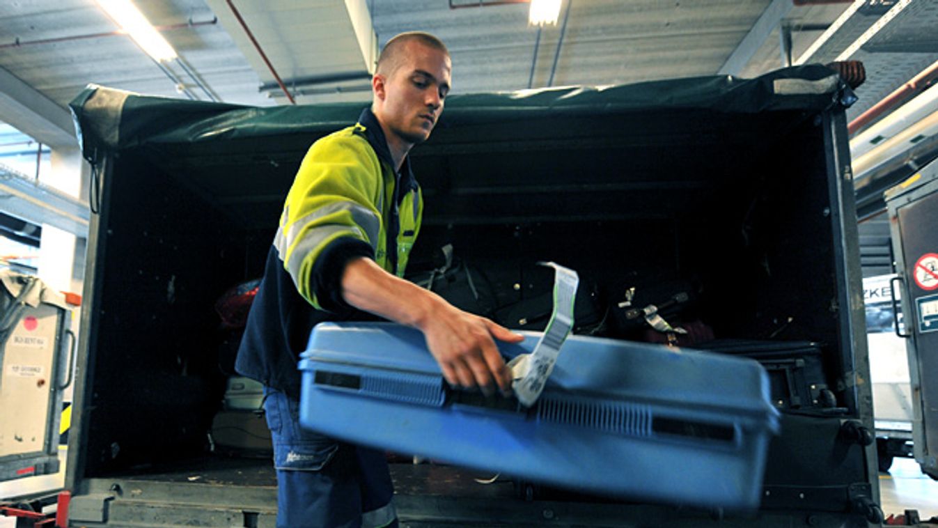 A személyzet a szállítókocsikba pakolja a csomagokat a brüsszeli repülőtéren, elveszett poggyászok 