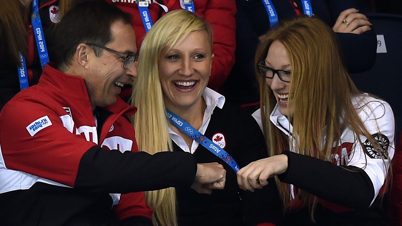 461452863 Canada's bobsleigh gold medallists Kaillie Humphries (C) and Heather Moyse (R) share a laugh with an unidentified man as they attend the Men's Curling Gold Medal Game between Canada and Great Britain at the Ice Cube Curling Center in Sochi durin