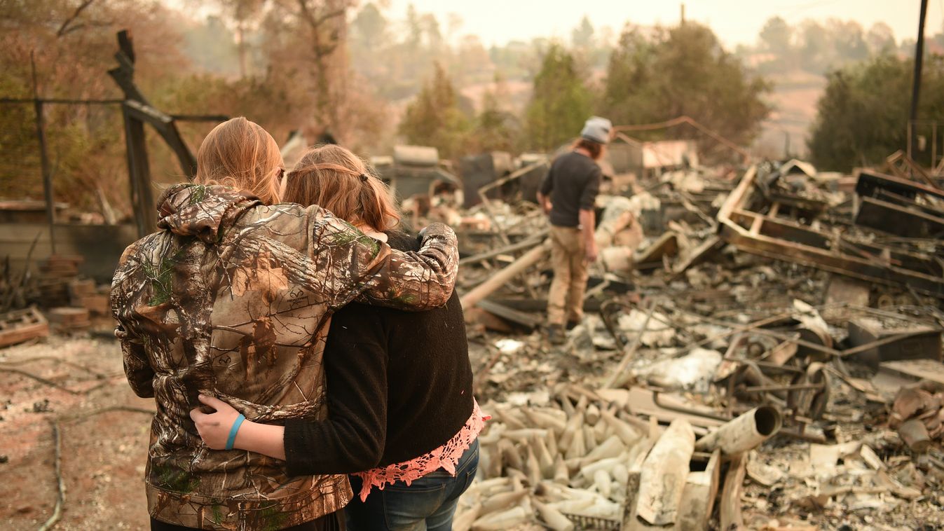 Horizontal Kimberly Spainhower hugs her daughter Chloe, 13, while her husband Ryan Spainhower (R) searches through the ashes of their burned home in Paradise, California on November 18, 2018. (Photo by Josh Edelson / AFP) 