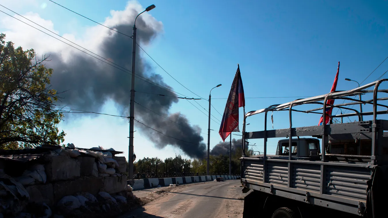 View of a pro-Russian separatist checkpoint as smoke rises from the airport area in the background in Donetsk, October 2, 2014. The airport, held by Ukrainian troops, is the scene of heavy fighting with pro-Russian separatists of the self-proclaimed Donet