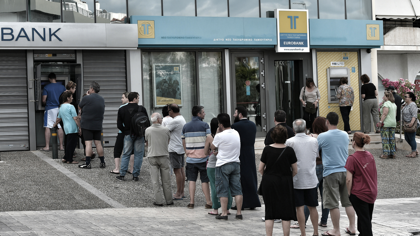 People stand in a queue to use ATM machines to withdraw cash at a bank in Athens on June 27, 2015. Greece will hold a referendum on July 5 on the outcome of negotiations with its international creditors taking place in Brussels on June 27, Prime Minister 