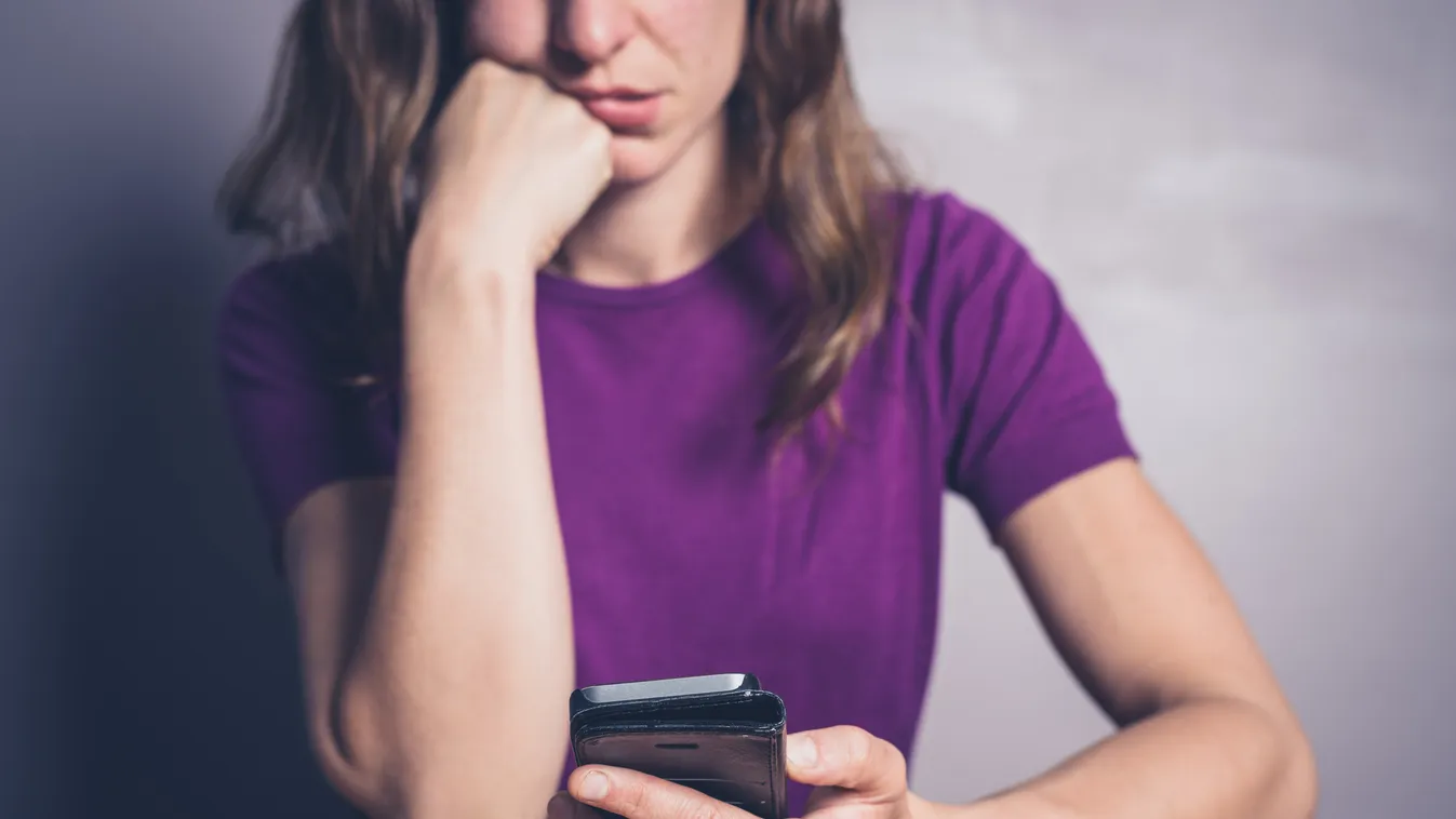 Bored woman using smartphone at table Smart Phone Text Messaging Women Females Message Young Adult Sitting Holding Irritation One Person Communication Boredom Technology Displeased Human Hand Tired People Internet Mobile Phone Telephone Table Application 