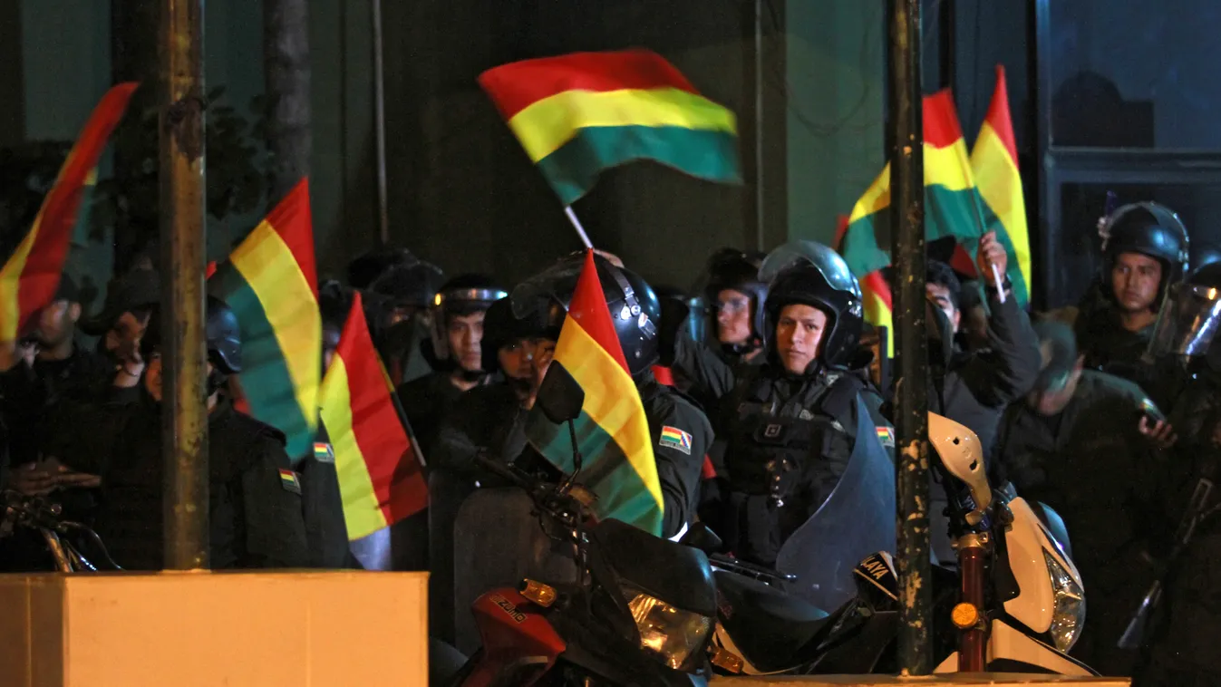 Horizontal Bolivian police officers wave Bolivia's national flag at a police station in Santa Cruz, Bolivia, on November 8, 2019, after saying they were joining a rebelion launched earlier by other units in the central city of Cochambamba. - Police in thr