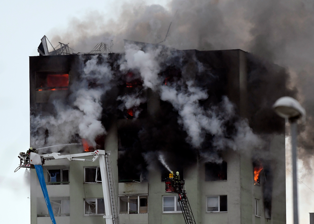 Eperjes, 2019. december 6.
Tűzoltók dolgoznak a lángok megfékezésén egy gázrobbanás miatt kigyulladt tizenkét emeletes épületnél Eperjesen 2019. december 6-án. A detonáció következtében legkevesebb öt ember életét vesztette, a lakók közül sokan a tetőn ra