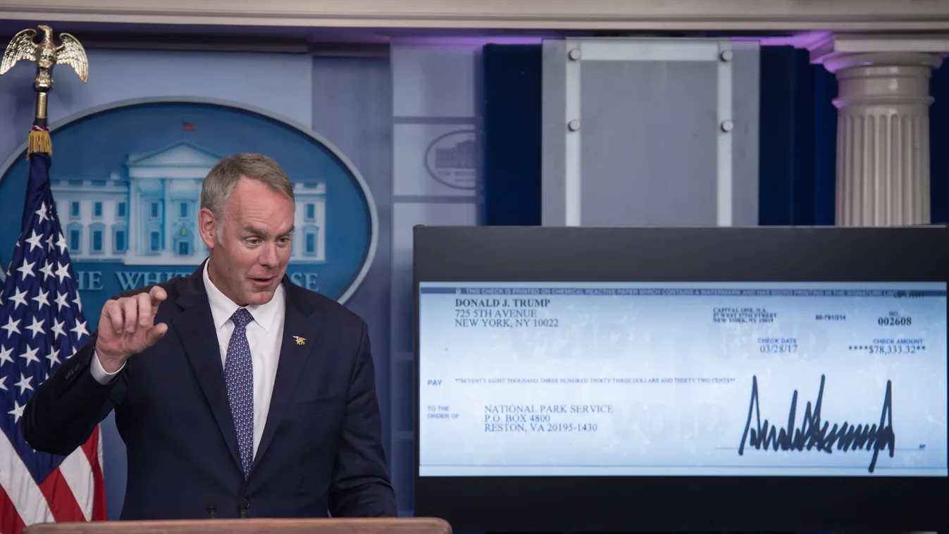 Horizontal US Interior Secretary Ryan Zinke speaks as the first quarter check of US President Donald Trump's salary which he donated to the National Park Service is displayed on a screen during the daily press briefing at the White House in Washington, DC