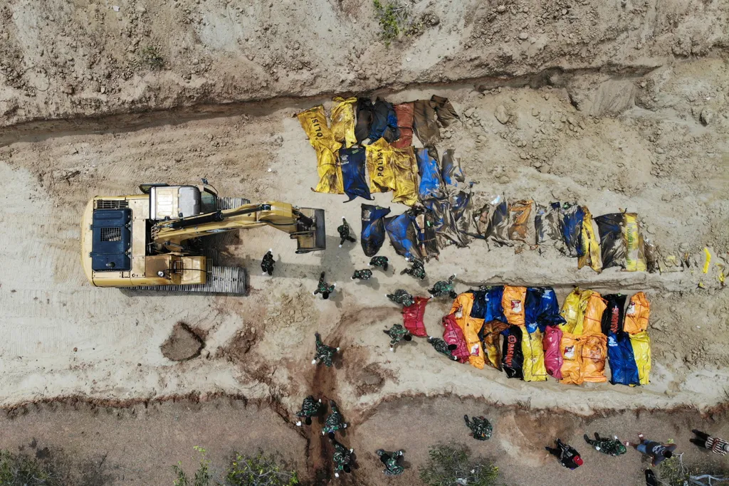 Horizontal NATURAL DISASTERS TSUNAMI CONSEQUENCES OF A CATASTROPHE EARTHQUAKE DAMAGE AERIAL VIEW MASS GRAVE BUILDING SITE EQUIPMENT TOMB VICTIM BAG -- AFP PICTURES OF THE YEAR 2018 --

This aerial photo shows Indonesian soldiers burying quake victims in a