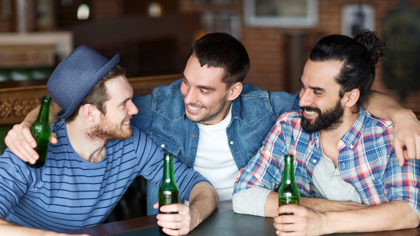 happy male friends drinking beer at bar or pub Pub Social Gathering Leisure Activity Beer Bottle Men Males Group Of People Bachelor Young Adult Smiling Talking Sitting Drinking Embracing Holding Customer Fun Southern European Descent Latin American and Hi