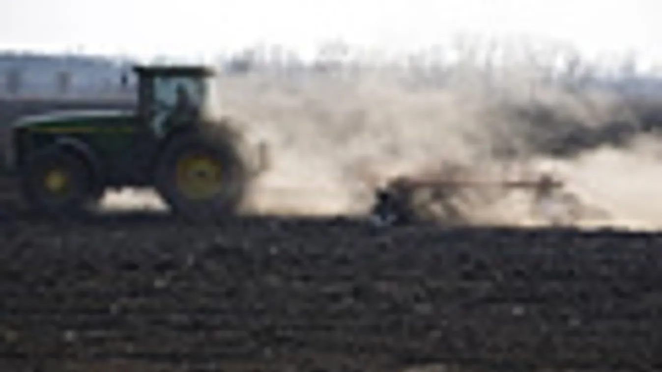 Tavaszi szárazság, traktor dolgozik a poros földeken, csapadékhiány
