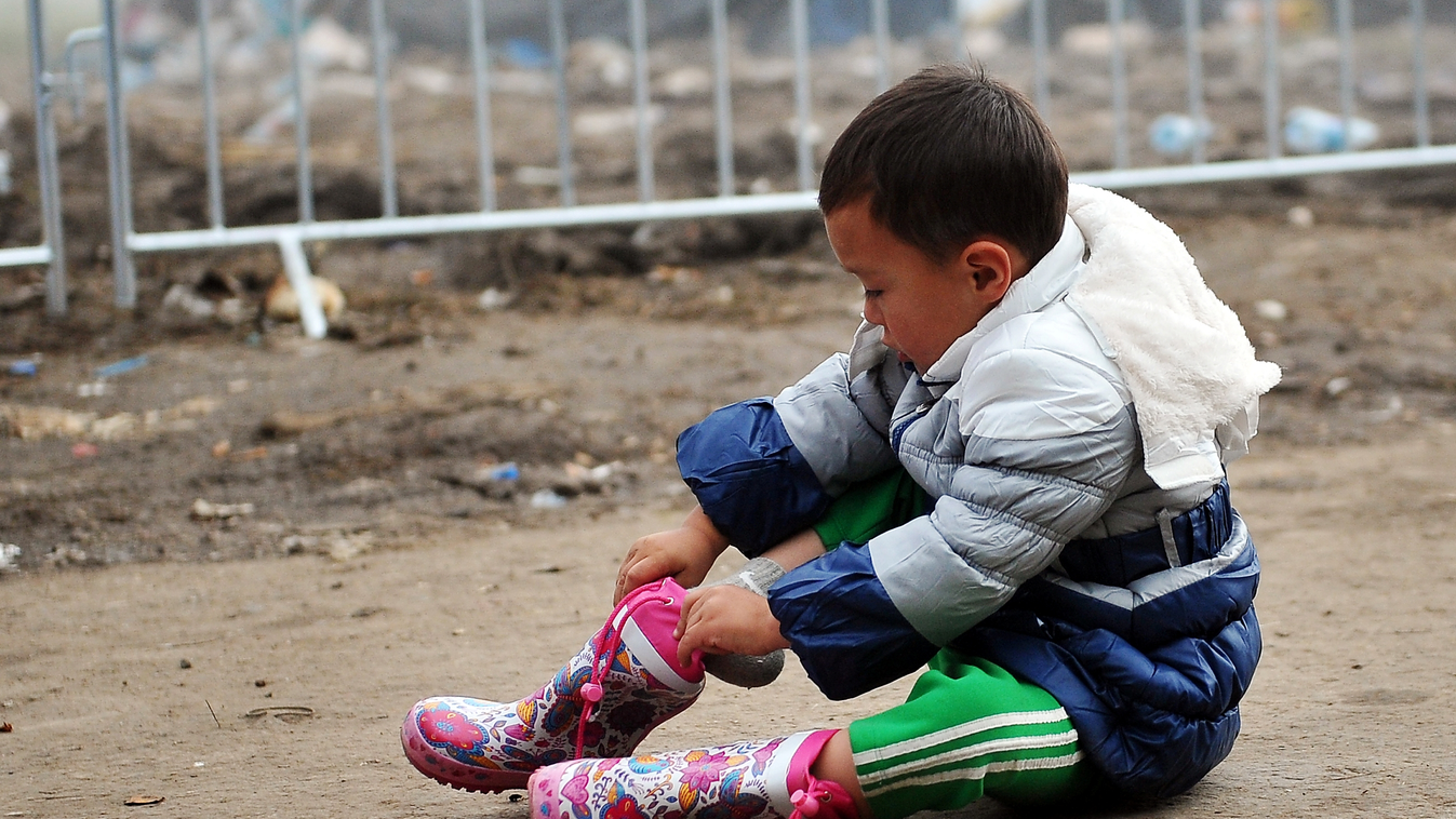 HORIZONTAL MIGRATION AND IMMIGRATION REFUGEE EXODUS CONSQUENCES OF WAR BORDER CHILD BOOTS A migrant child puts his boots, before crossing Serbian-Croatian border in the village of Berkasovo, on October 27, 2015. The European Union pledged to help set up 1