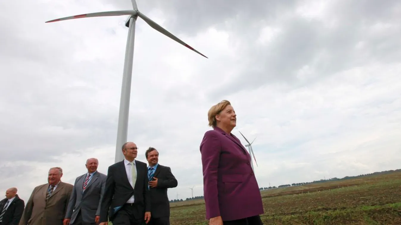 German Chancellor Merkel walks in front of wind turbines during her visit of the 'WIND-projekt' wind turbines park in Ravensberg 