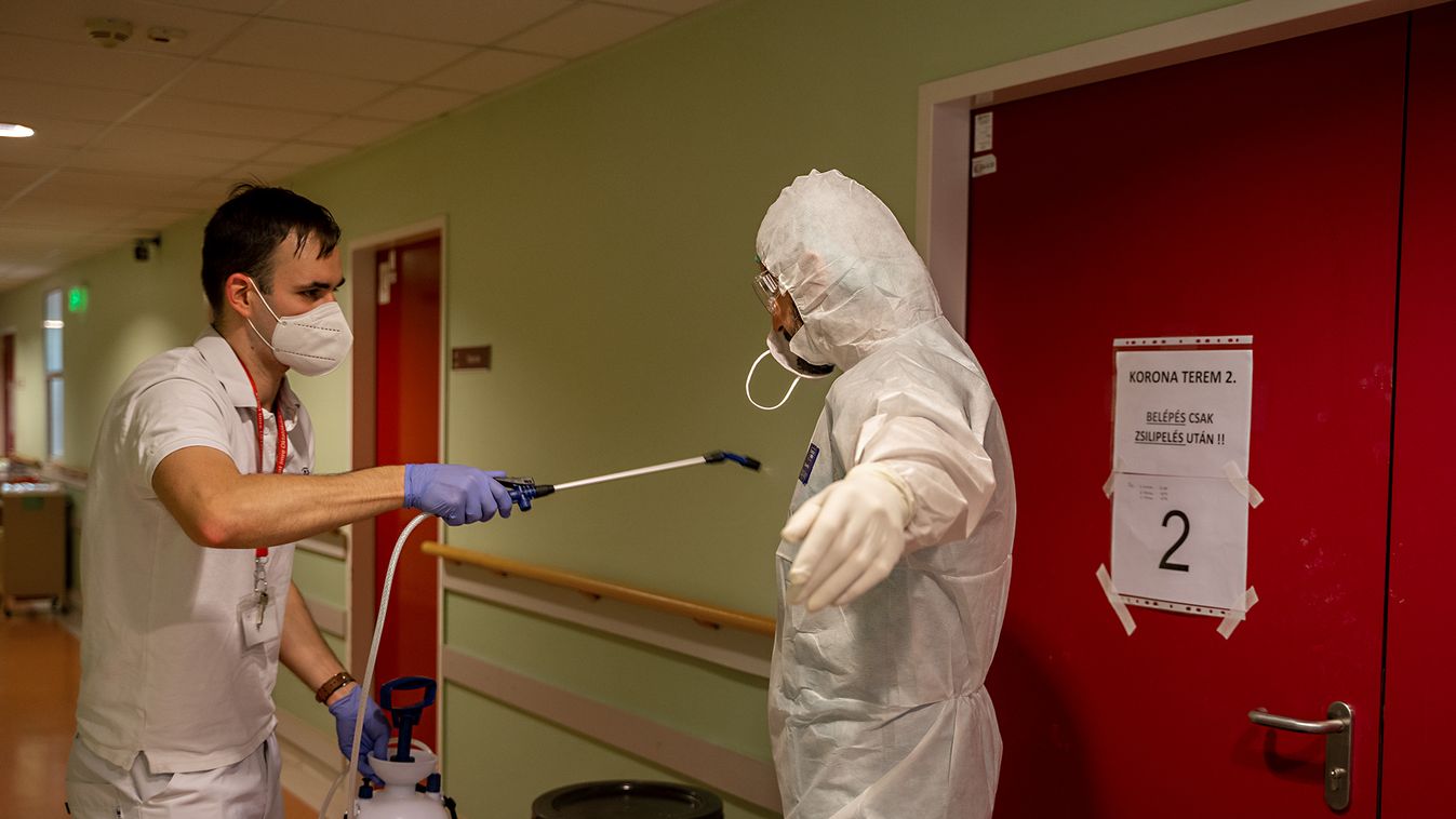 A Szent Imre Kórházban fertőtlenítik az orvos védőruháját, miután kijött a koronavírusos beteg izolált kórterméből. 