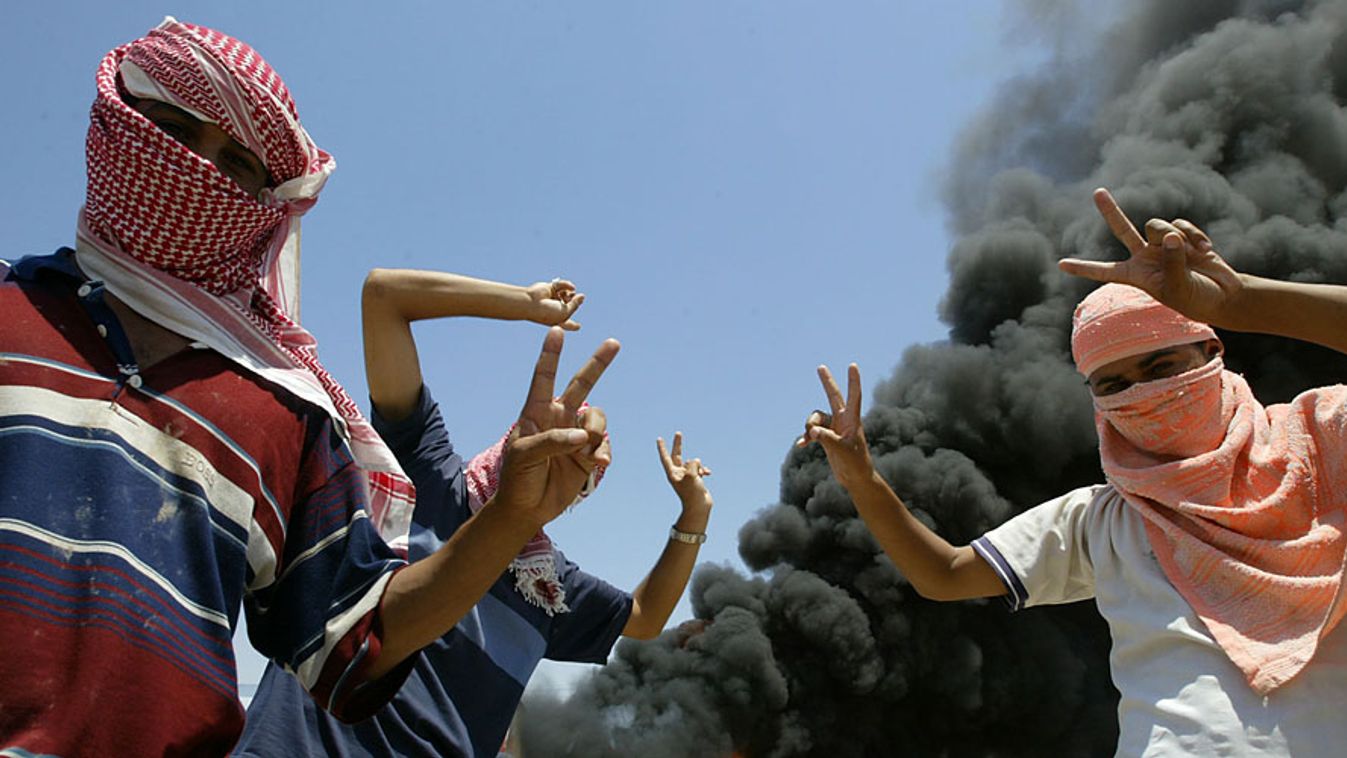 iraki fiatalok egy lángoló tartálykocsi előtt 2004- júniusában