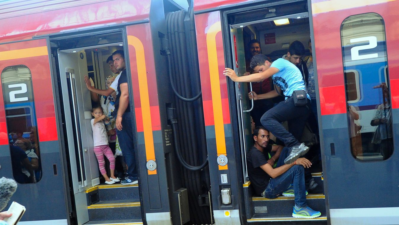 HORIZONTAL MIGRATION AND IMMIGRATION REFUGEE EXODUS CONSQUENCES OF WAR TRAIN CARRIAGE MAN CHILD RAILWAY STATION Migrants travel on the train to Austria and Germany at the Eastern (Keleti) railway station in Budapest on August 31, 2015. The EU is grappling