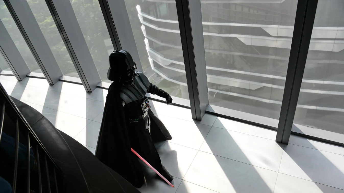 A staff member dressed as the Darth Vader (C) character from George Lucas' Star Wars films arrives for photographers at the opening of Disney's Lucasfilms' new animation production facility, the Sandcrawler in Singapore on January 16, 2014. The award-winn