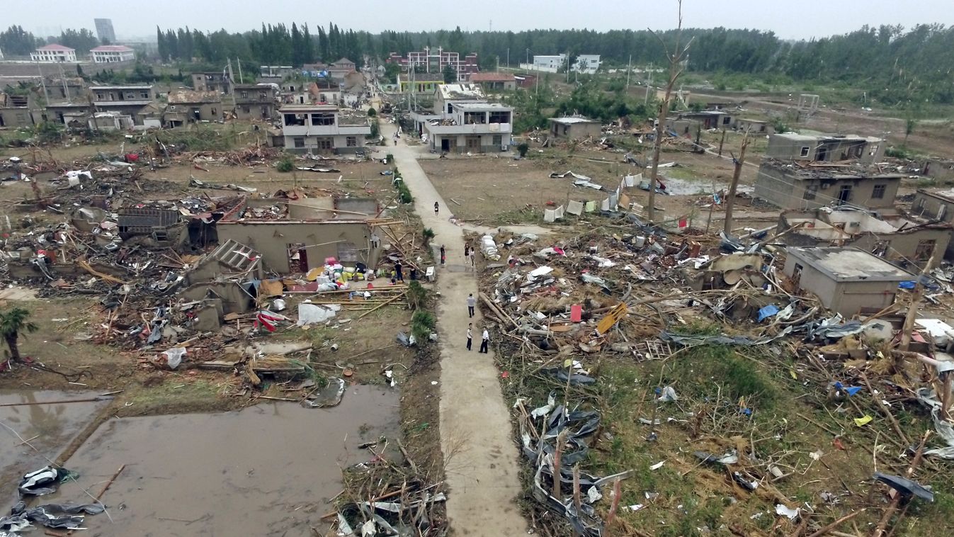 Horizontal Residents walk in the rubble of destroyed houses after a tornado in Funing, in Yancheng, in China's Jiangsu province on June 24, 2016.  
Extreme weather, including hailstorms, heavy rain and a tornado, killed 78 and injured dozens in China's ea