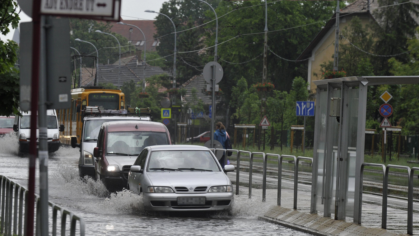 Budapest, 2019. május 29.
Autók haladnak a hirtelen jött felhőszakadás miatt vízzel borított XIX. kerületi Ady Endre úton 2019. május 29-én. További eső, zápor, zivatar várható, és elsősorban a nyugati tájakon kifejezetten őszies hőmérsékletre kell számít