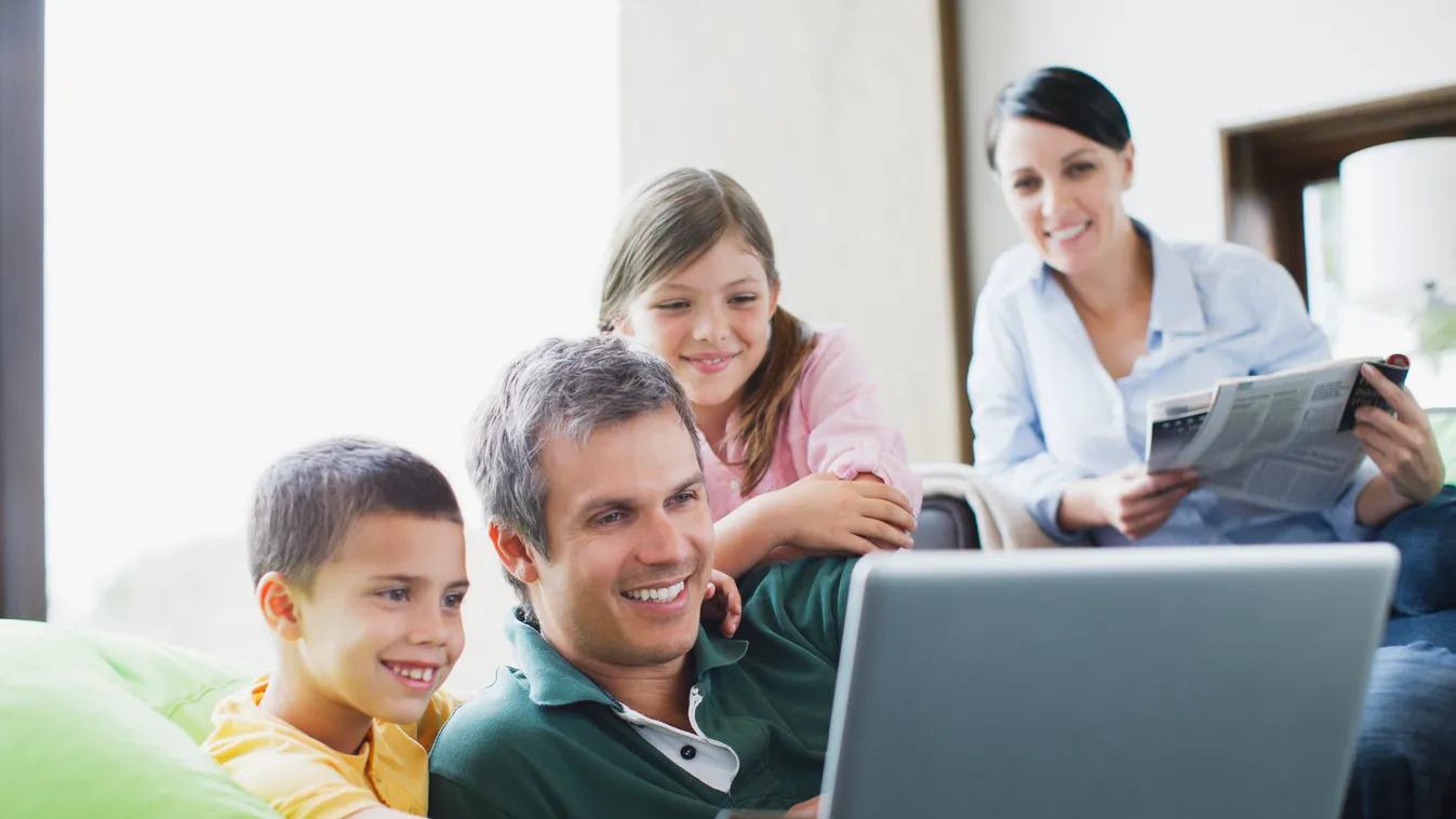Family using laptop together 35-39 years 6-7 years 8-9 years accessibility bedfordshire bonding boy boys brother buying casual clothing catalog caucasian childhood color image commerce connection consumer consumerism convenience copy space credit credit c