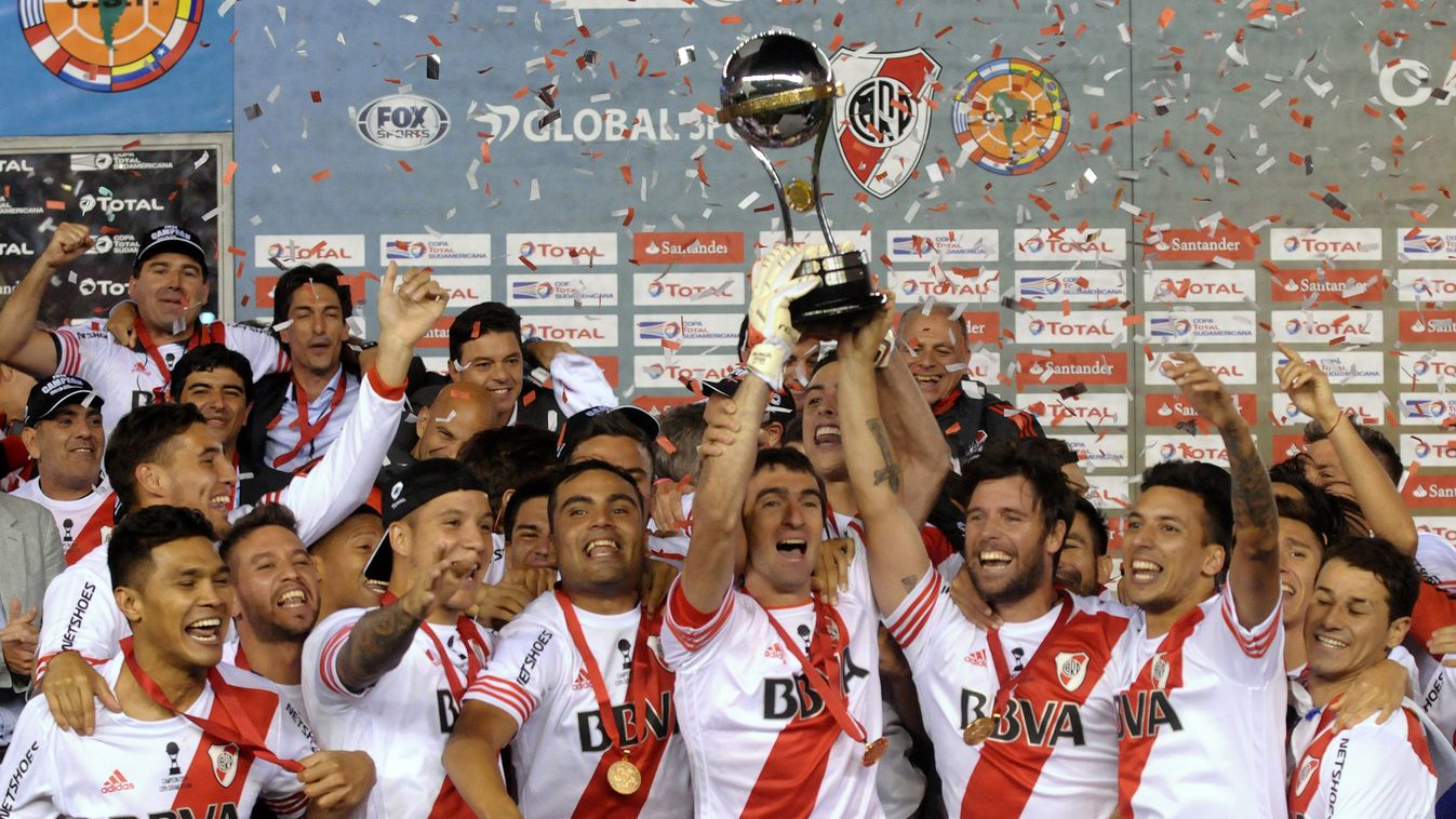 Argentina's River Plate goalkeeper Marcelo Barovero (C) and forward Fernando Cavenaghi  hold the Copa Sudamericana 2014 trophy after defeating Colombia's Atletico Nacional  in the second leg final football match at the Monumental stadium in Buenos Aires, 