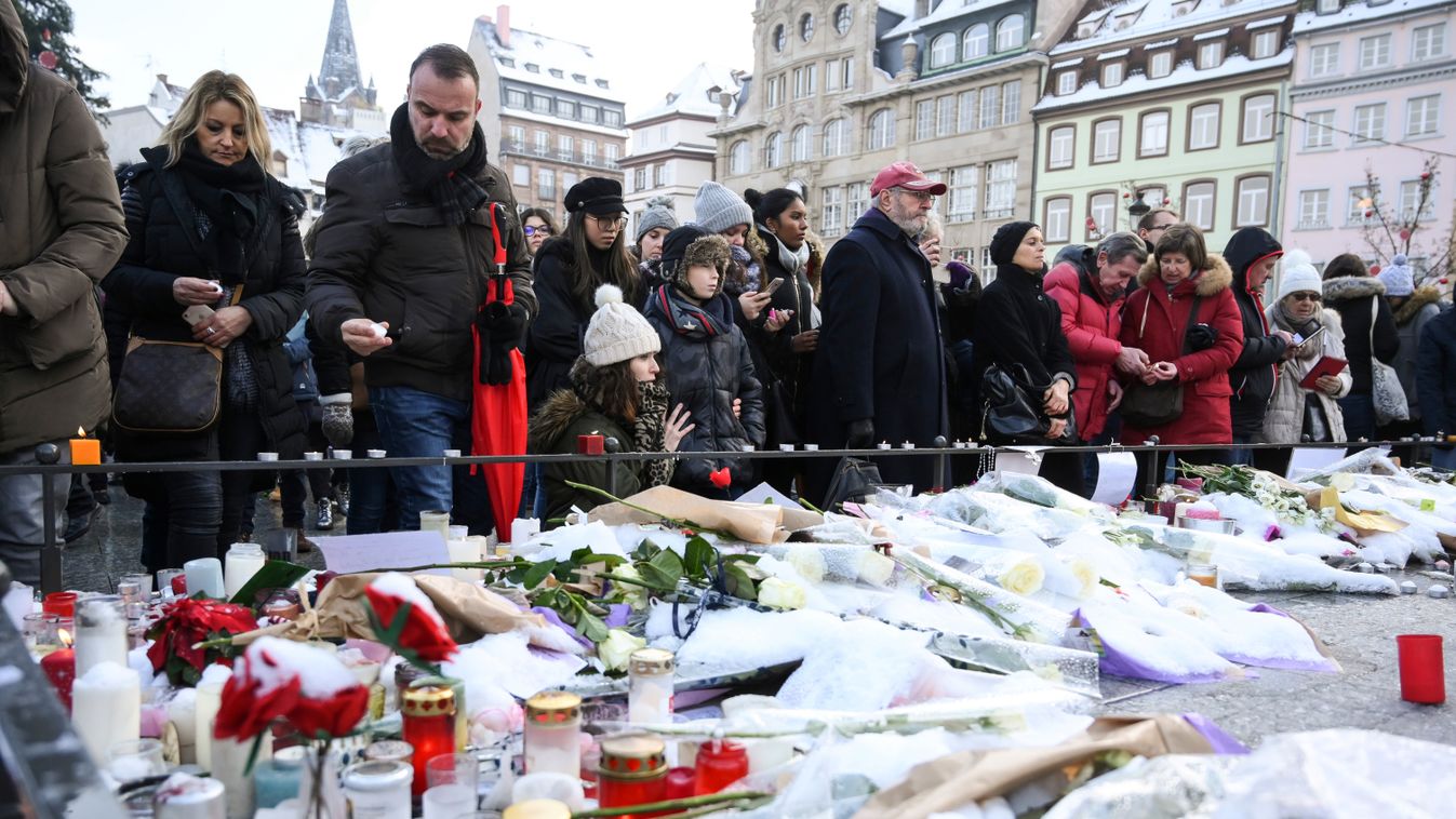 Horizontal People light-up candles and deposit flowers during a gathering around a makeshift memorial at Place Kleber, in Strasbourg, on December 16, 2018 to pay a tribute to the victims of Strasbourg's attack. - Four people were killed and 12 wounded whe