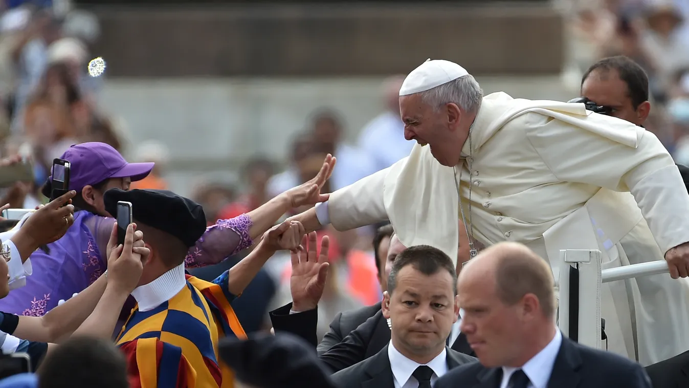Ferenc pápa heti audienciáján kezet ráz az ott lévőkkel a vatikáni szent Péter téren 