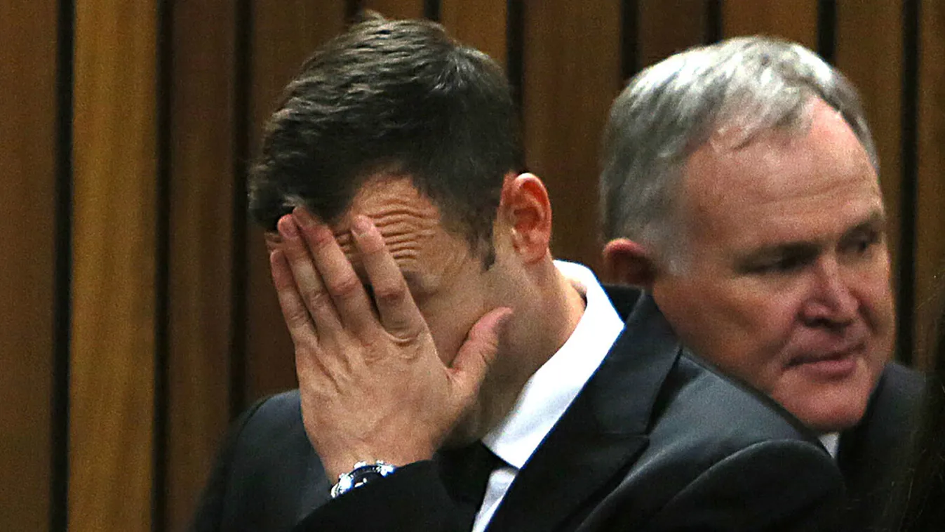 Oscar Pistorius (L) gestures next to his attorney Barry Roux (R) upon his arrival at the court on the third day of his trial at the North Gauteng High Court in Pretoria, on March 5, 2014.  Oscar Pistorius's defence sought to prove that a married couple wh
