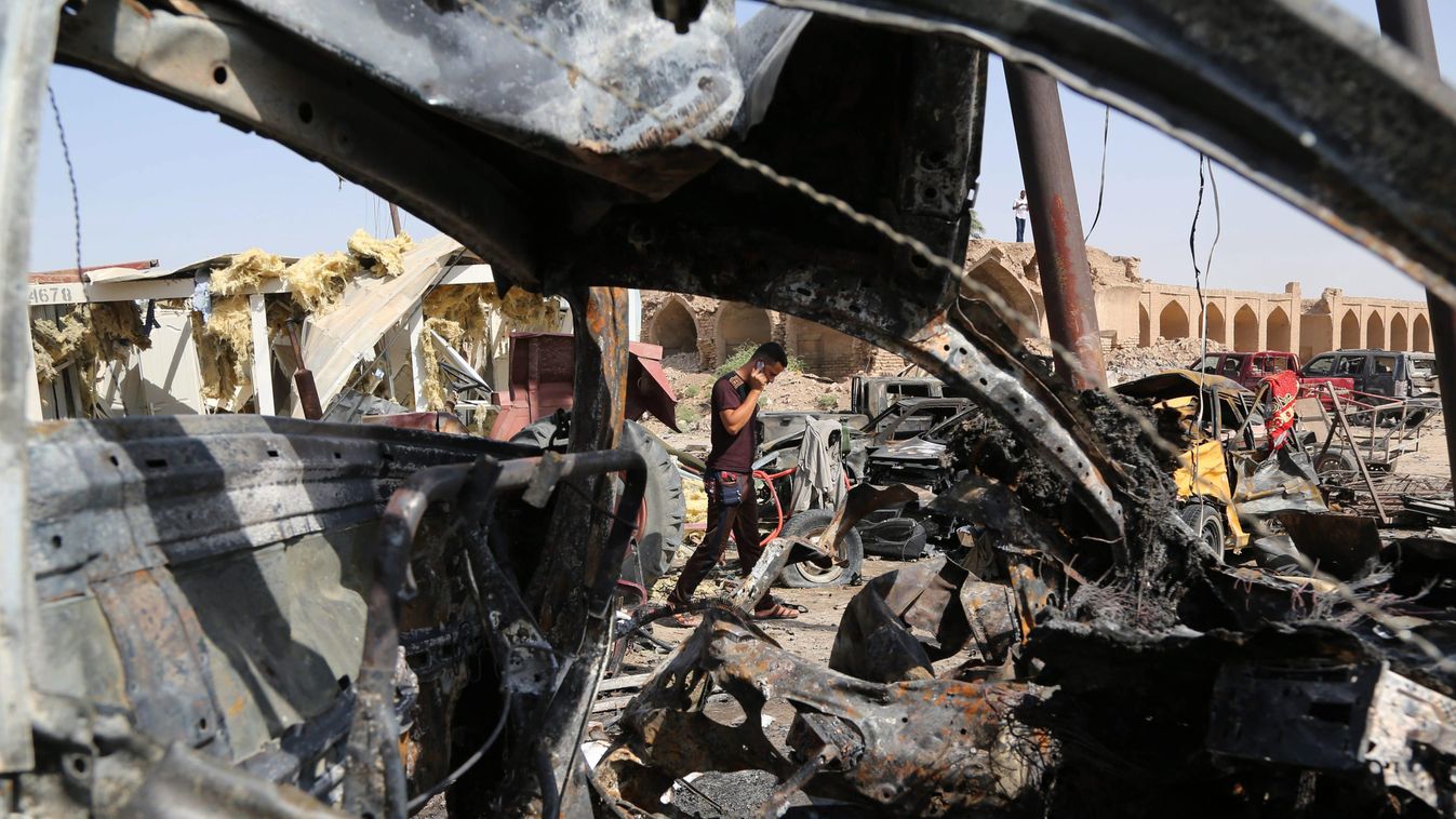 Hán-Báni-Szaad, 2015. július 18.
Ronccsá vált járművek a pokolgépes merénylet helyszínén,a Bagdadtól 30 km-re északkeletre fekvő Hán-Báni-Szaad város piacán 2015. július 18-án. Előző este egy öngyilkos merénylő levegőbe röpítette robbanóanyaggal megpakolt