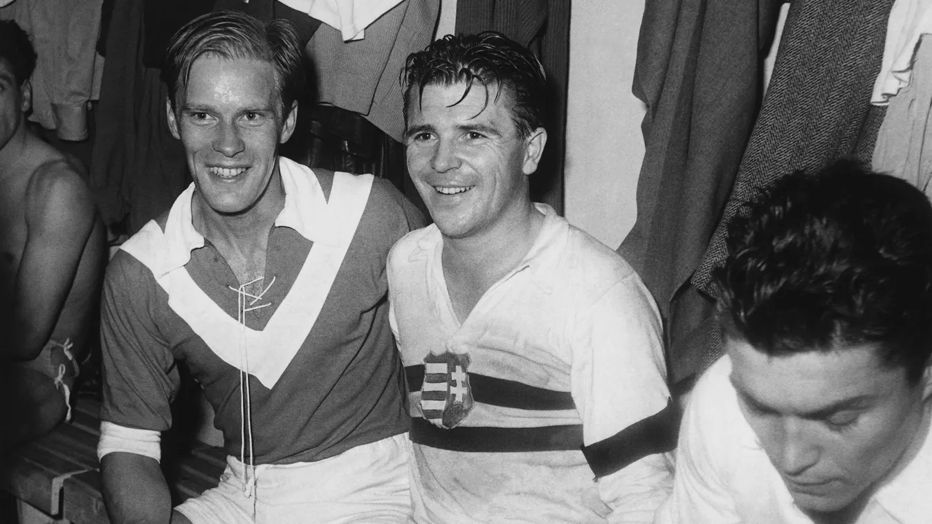 Ferenc Puskas in the Changing Room .Fußball .Personen .Sport Kossuth_Wappen Kossuth_coat_of_arms People SPO SPORT Umkleidekabine Wappen black_ribbon CHANGING ROOM COAT OF ARMS crape emblem FOOTBALL football_team fußballmannschaft lächeln mourning_band SMI