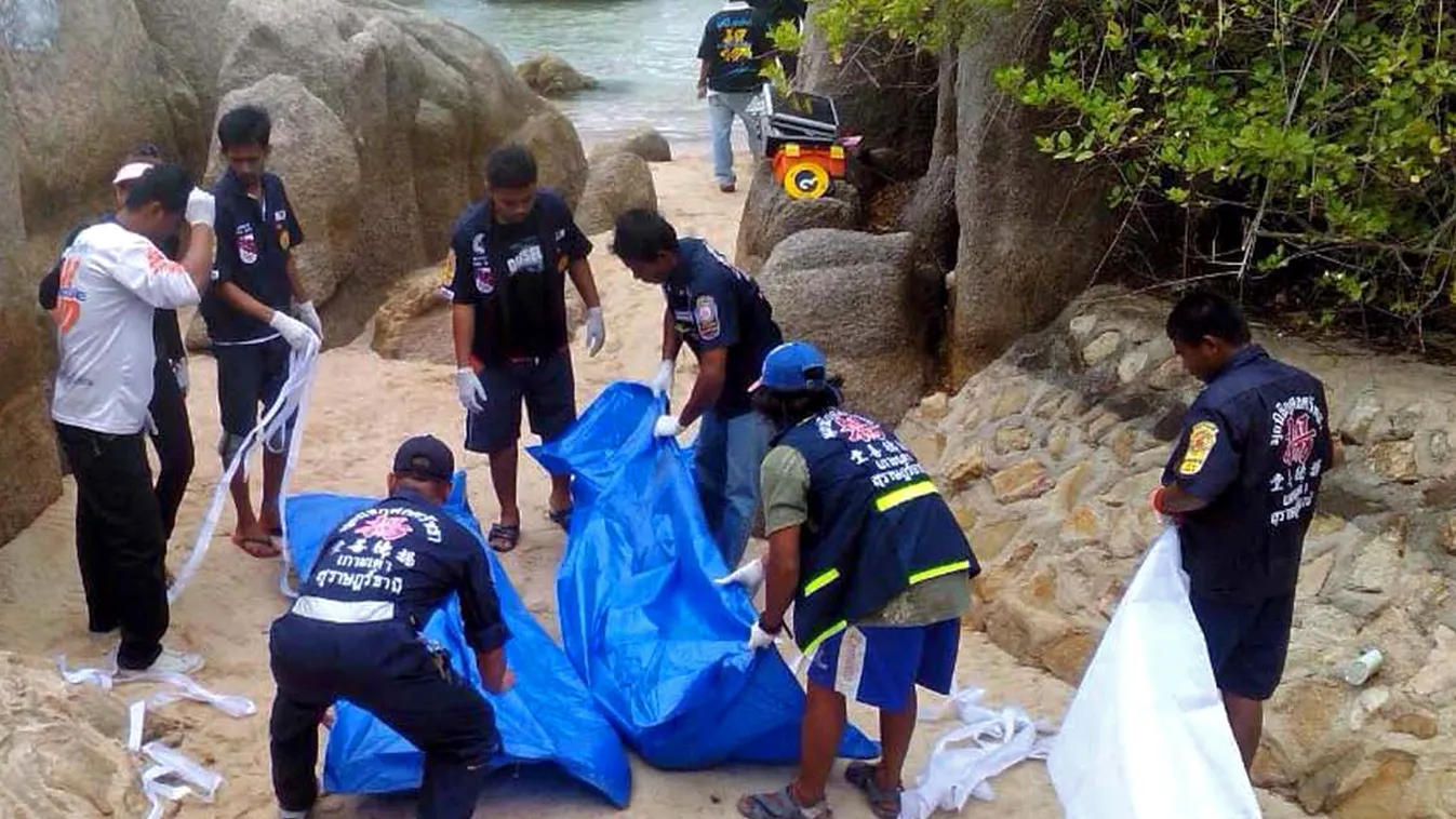 Thai workers carry the bodies of two British tourists on Koh Tao island in the Surat Thani province of southern Thailand on September 15, 2014. The naked bodies of two British tourists were found on a Thai beach, police said, sparking a murder probe on th
