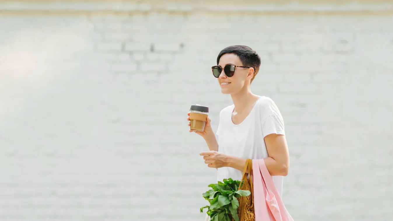 Young woman in light summer clothes with a eco bag of vegetables, greens and reusable coffee mug. Sustainable lifestyle. Eco friendly concept. summer produce healthy organic market grocery vegetables green bag beverage cloth coffee coffee cup concept copy