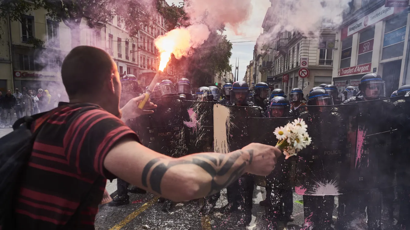 Tüntető egy csokor virággal és egy fáklyával a rohamrendőrökkel szemben Lyonban egy tüntetésen. Franciaországban az elmúlt két hónapban rendszeressé váltak a kormány tervezett munkajogi reformjának visszavonását követelő tüntetések. labour demonstration T