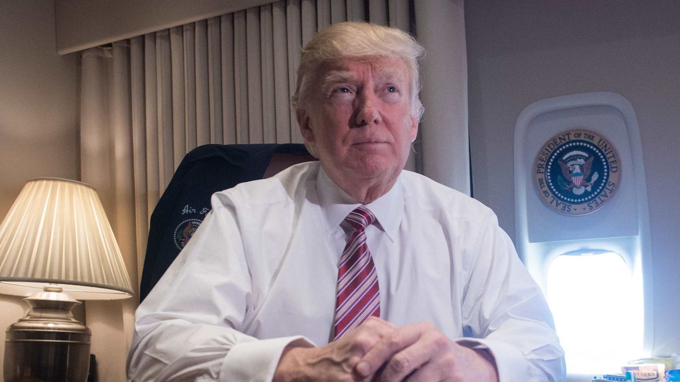 Horizontal US President Donald Trump poses in his office aboard Air Force One at Andrews Air Force Base in Maryland after he returned from Philadelphia on January 26, 2017. / AFP PHOTO / NICHOLAS KAMM 