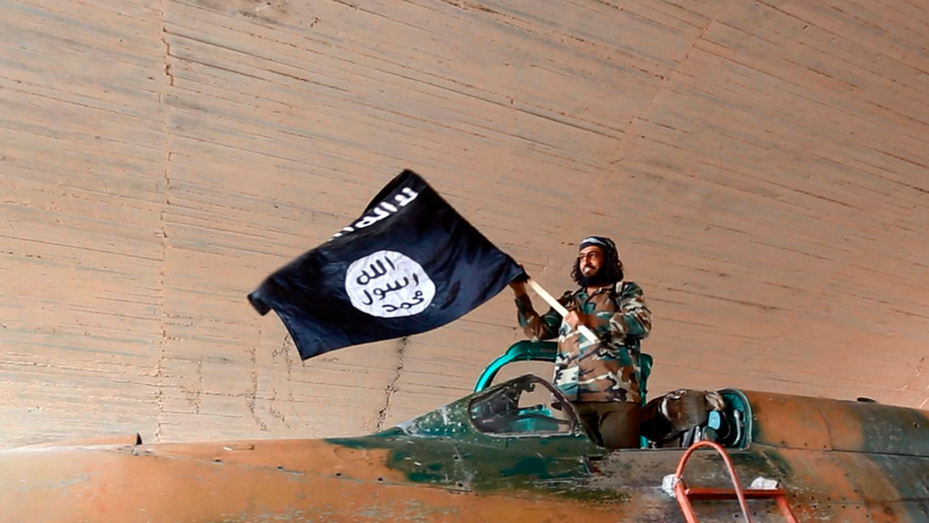 Tabka, 2014. augusztus 24.
Az Iszlám Állam (IÁ) szélsőséges iszlamista szervezet Rakkai Médiaközpontja által közzétett dátum nélküli képen az IÁ harcosa a szervezet zászlajával egy zsákmányolt harci gépen, miután az IÁ elfoglalta a szíriai Rakka tartomány