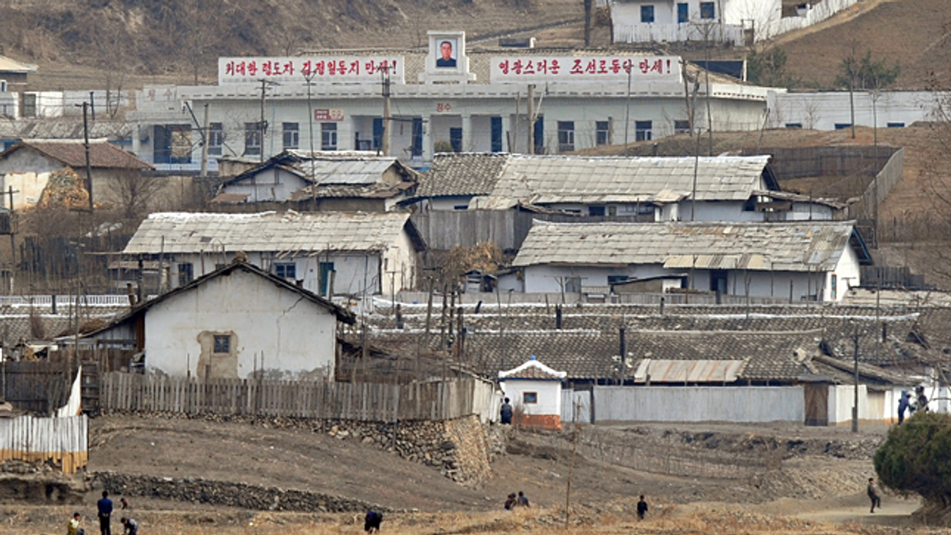 Észak-Korea, éhinség, aszály, Kim Ir SZen portréja egy faluban a Jalu folyó mentén 