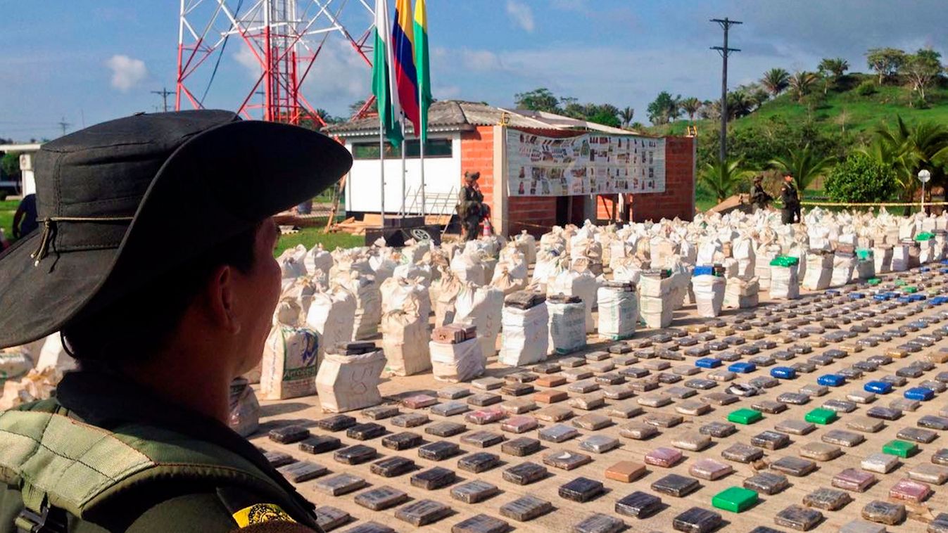 Horizontal Handout picture released by the Colombian police showing a Colombian police officer standing guard over eight tons of seized cocaine in Turbo, Antioquia department, on May 15, 2016.
General Jorge Nieto, the head of the Colombian police, said th