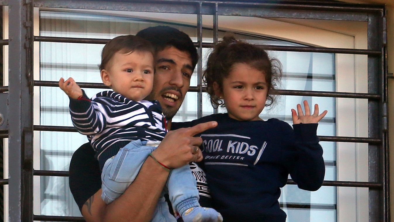 HORIZONTAL FOOTBALL WORLD CUP BUST CHILD Uruguay's striker Luis Suarez, banned from football for four months after biting an opponent at the World Cup, holds his children Benjamin and Delfina as he greets fans from his mother's home in Lagomar, in the dep