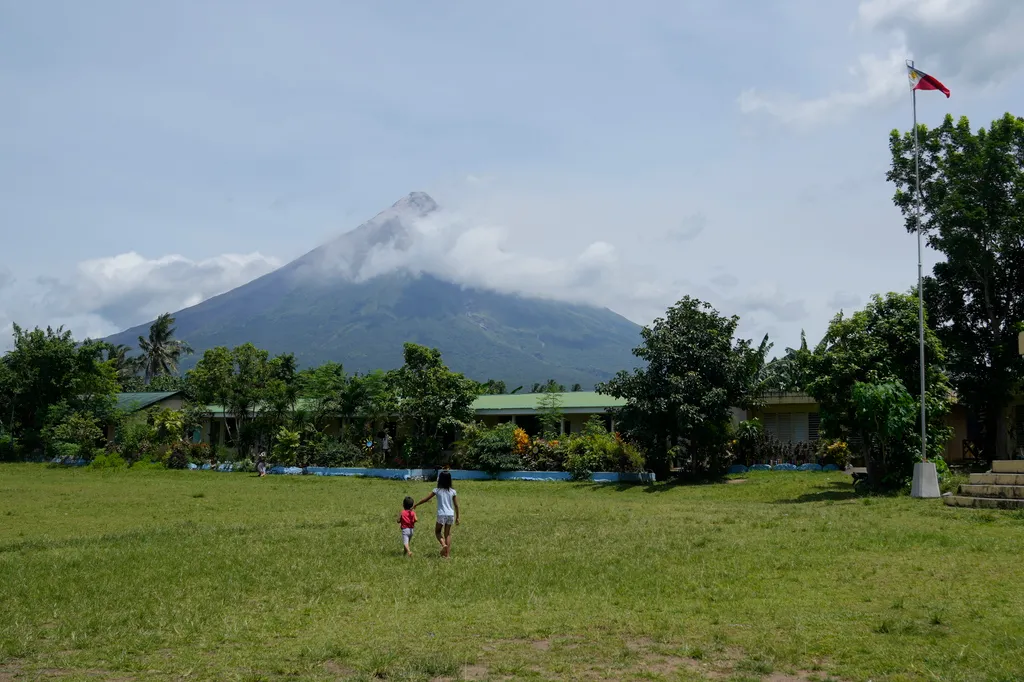Fülöp-szigeteki Mayon vulkán Manila  és hamut lövell ki a Fülöp-szigeteki Albay tartományban fekvő Santo Domingo kitelepítési központjából nézve 2023. június 13-án. Az ország legaktívabb tűzhányójának kitörése miatt több mint 13 ezer embe 