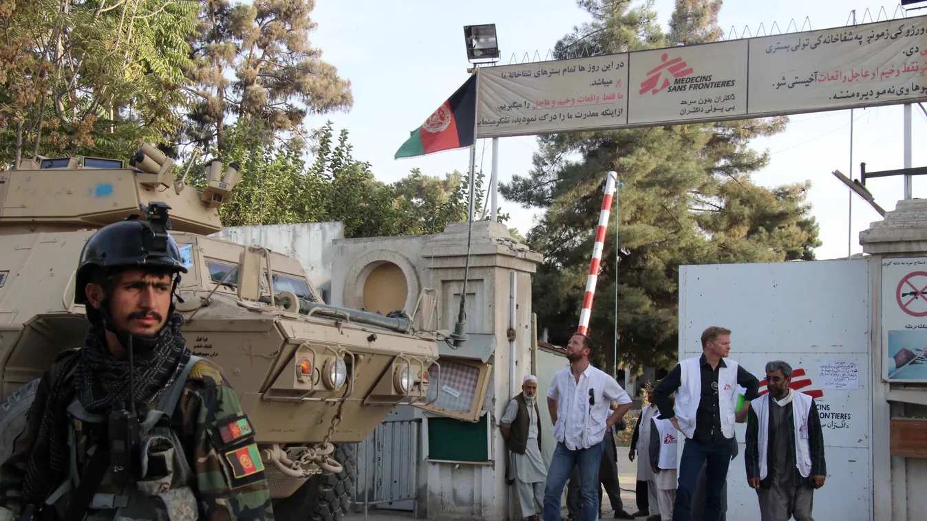 In this photograph taken on October 15, 2015, the staff director for Doctors Without Borders (MSF) in Afghanistan (2R), MSF staff and Afghan military personnel stand outside the entrance to the MSF hospital in Kunduz. Doctors Without Borders accused the U