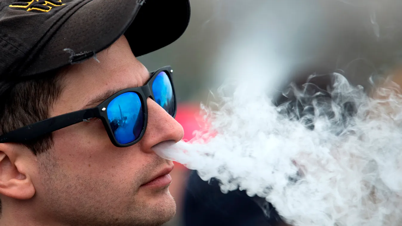 Horizontal Demonstrator vapes during a consumer advocate groups and vape storeowners rally outside of the White House to protest the proposed vaping flavor ban in Washington DC on November 9, 2019. (Photo by Jose Luis Magana / AFP) 