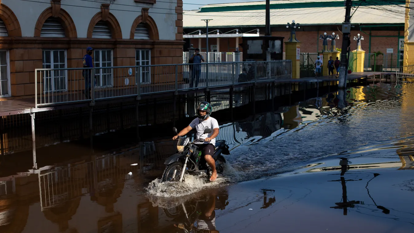 A man rides a motorbike along a flooded street in the city centre of Manaus, capital of the Brazilian Amazonas State, on June 1, 2021, the day the water of the Rio Negro, a tributary of the Amazon river, reached 29,98 meters, making a new record level of 